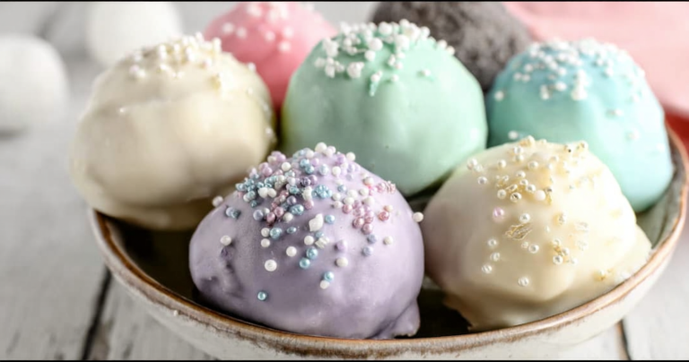 Colorful Oreo truffles with almond bark drizzle and sprinkles on a decorative plate.