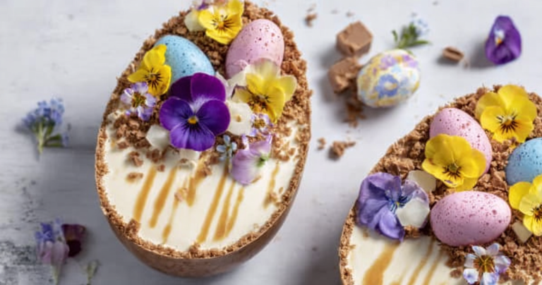 Easter egg cheesecake with mini chocolate eggs and chocolate drizzle, decorated with spring flowers