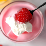 Delicious Greek yogurt jello served in a bowl with fresh berries and whipped cream on top.