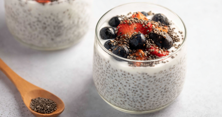 Creamy yogurt chia pudding served with fresh berries and nuts on a rustic wooden table.