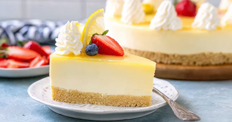 Slice of no-bake jello cheesecake topped with berries and whipped cream on a decorative plate.
