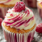 Raspberry Swirl Cupcake elegantly displayed on a plate, showcasing the red and white frosting swirl.