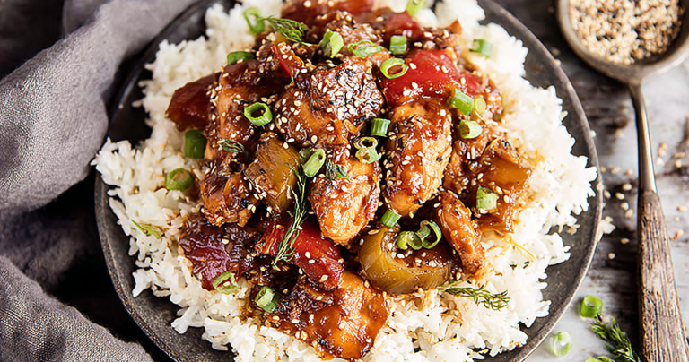 Delicious Sweet Hawaiian Crockpot Chicken served with rice and garnished with fresh green onions and sesame seeds.