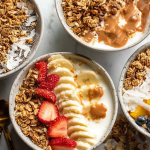 Granola and yogurt bowl with fresh berries, honey drizzle, and a sprinkle of granola on top.