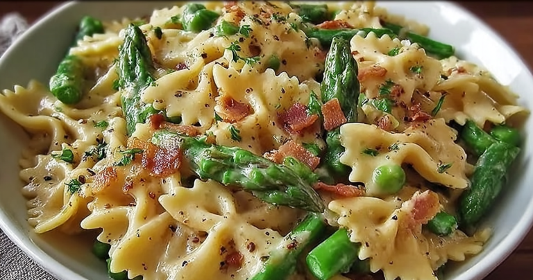 Close-up of creamy pasta with asparagus, toasted pine nuts, and parsley in a rustic bowl.