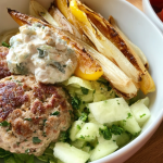 Slice of Irish tea cake on floral china plate next to a cup of tea on a wooden table.