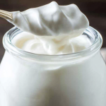 Close-up of a muffin topped with Greek yogurt icing and a sprinkle of cinnamon.