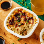 Close-up of TikTok Dumpling Lasagna showcasing layers of dumplings, sauce, and garnishes.