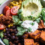 Colorful Sweet Potato Taco Bowl with tomatoes, avocado, and cilantro