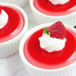 Delicious Greek yogurt jello cups garnished with raspberries and mint, perfect for a low-calorie dessert.
