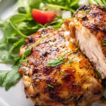 Baked chicken thighs marinated in yogurt, served with fresh herbs and spices.