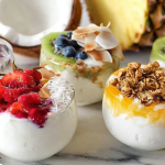 Greek yogurt breakfast bowl with fresh berries and honey on wooden table