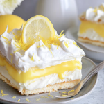 Slice of Lemon Lush Cake garnished with lemon slices and mint leaves