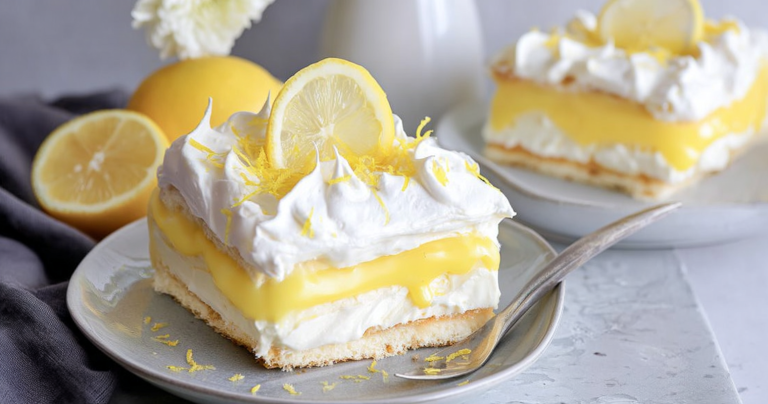 Slice of Lemon Lush Cake garnished with lemon slices and mint leaves
