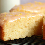 Lemon yogurt cake with glaze and lemon slices on a wooden table