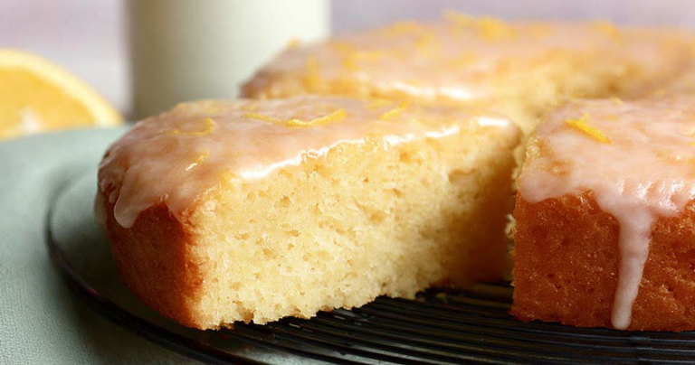 Lemon yogurt cake with glaze and lemon slices on a wooden table