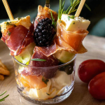 Colorful individual charcuterie cups filled with cheese, meats, fruits, and nuts on a festive table setting.