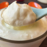 Bowl of copycat vanilla yogurt topped with fresh berries and honey, emphasizing its creamy texture.