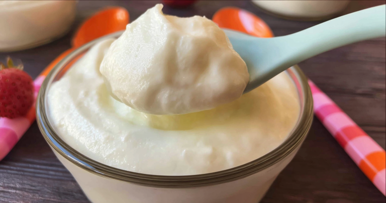 Bowl of copycat vanilla yogurt topped with fresh berries and honey, emphasizing its creamy texture.