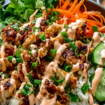 Bang Bang Chicken Bowl with avocado, cilantro, and sesame seeds over rice and vegetables