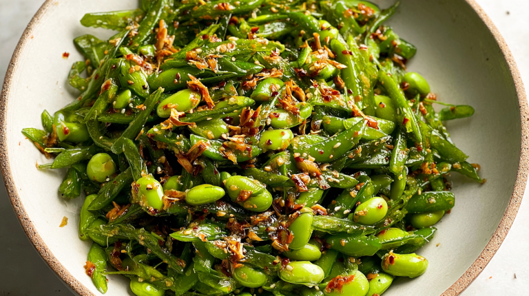 Chili crisp snap pea salad with snap peas, edamame, cilantro, and scallions in a rustic bowl.