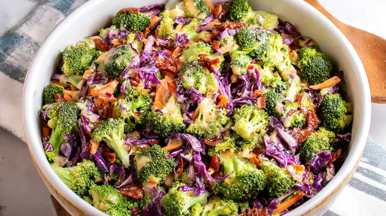 Crunchy broccoli salad with purple cabbage, bacon bits, and honey Dijon vinaigrette in a bright bowl.