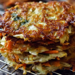 Crispy cabbage fritters served on a plate with herbs and a dipping sauce.