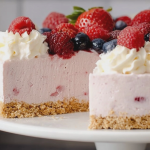 Slice of no-bake berry cheesecake topped with berries and whipped cream on a rustic wooden table.