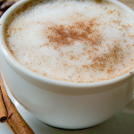 Stylish homemade cappuccino topped with cocoa powder on a wooden table.