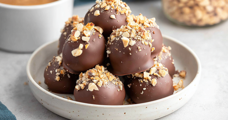 Close-up of hazelnut truffles with crushed hazelnuts on a wooden board