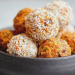 Carrot cake energy balls with shredded coconut on a white plate, healthy no-bake snack.