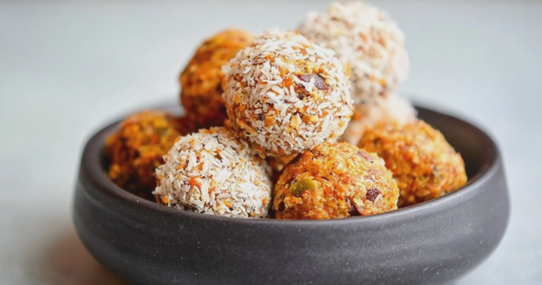 Carrot cake energy balls with shredded coconut on a white plate, healthy no-bake snack.